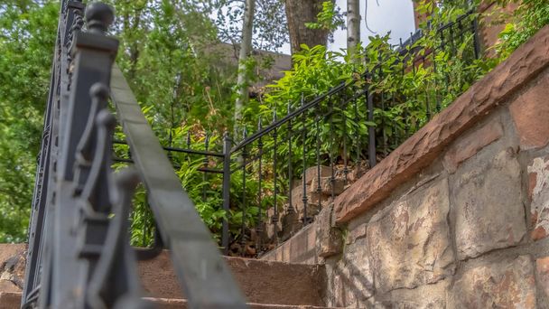 Panorama Close up of outdoor stairs with black metal handrail against a stone wall - Photo, Image