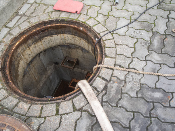 Open Sewer cleaning with hose and rope - 写真・画像