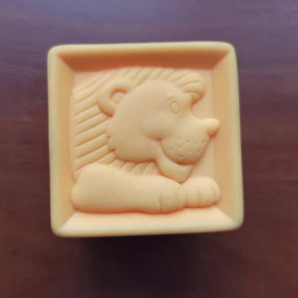 Orange toy cube with lion on wooden background - Photo, Image