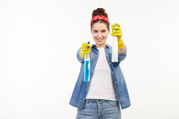 Pretty woman in work-wear uses window cleaning supplies. - Photo, image