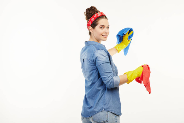 Pretty woman in work-wear uses different coloured rags. - Фото, зображення