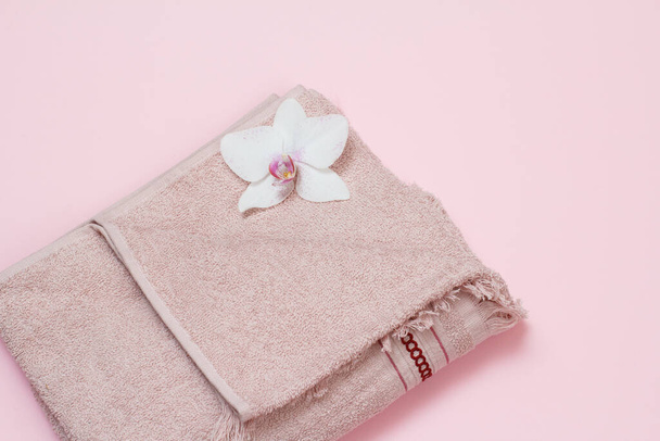 Soft terry towel with flower on pink background. - Foto, Bild