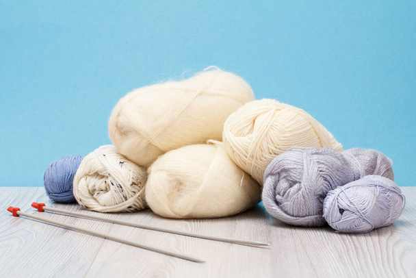 Wollen garen voor het breien. ballen van natuurlijke wol en breinaalden - Foto, afbeelding