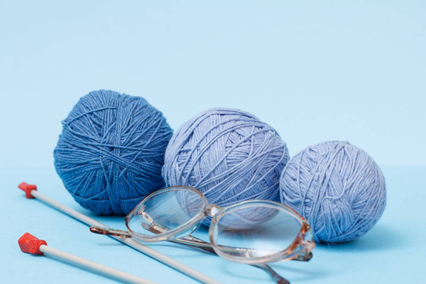 Filati di lana per maglieria. Palline di filati di lana naturale e ferri da maglia
 - Foto, immagini