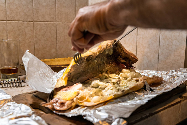 Zelfgemaakte gegrilde dorado vis met groenten verpakt in aluminiumfolie op rustieke tafel. Bovenaanzicht. - Foto, afbeelding