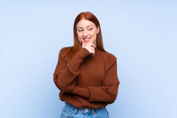 Young redhead woman over isolated blue background looking to the side - Foto, Imagem