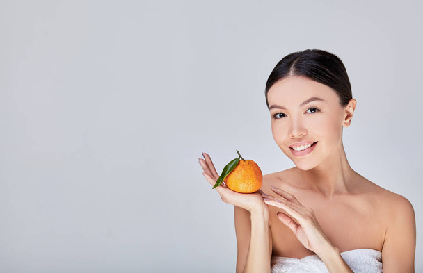 Okouzlující asijský model s citrusy v ruce. - Fotografie, Obrázek