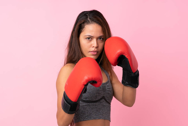 Jeune fille sportive brésilienne sur fond rose isolé avec des gants de boxe - Photo, image