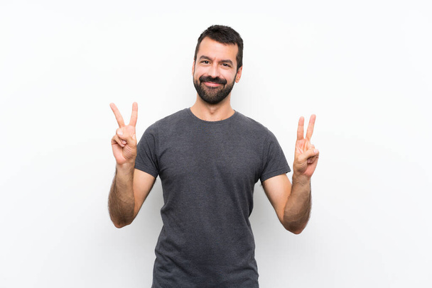 Young handsome man over isolated white background showing victory sign with both hands - Foto, afbeelding