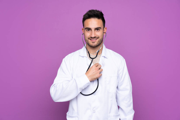 Orvosi köpenyt és sztetoszkópot viselő fiatalember - Fotó, kép