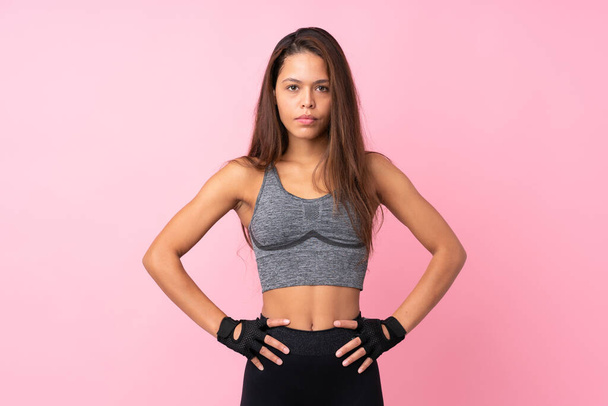 Giovane sport ragazza brasiliana su isolato sfondo rosa in posa con le braccia al fianco
 - Foto, immagini
