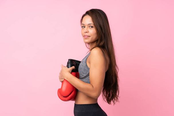 Junge Sport brasilianische Mädchen über isolierten rosa Hintergrund mit Boxhandschuhen - Foto, Bild