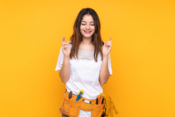 Young electrician woman over isolated on yellow background laughing - Photo, Image