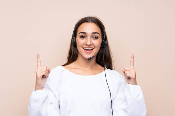 Young telemarketer woman over isolated background pointing up a great idea - Photo, image