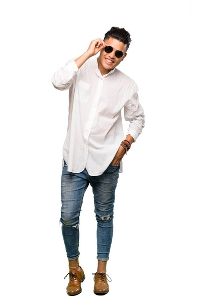 Um tiro de comprimento total de um jovem com óculos e surpreso sobre fundo branco isolado
 - Foto, Imagem