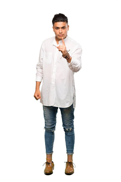 A full-length shot of a Young man frustrated and pointing to the front over isolated white background - Фото, зображення