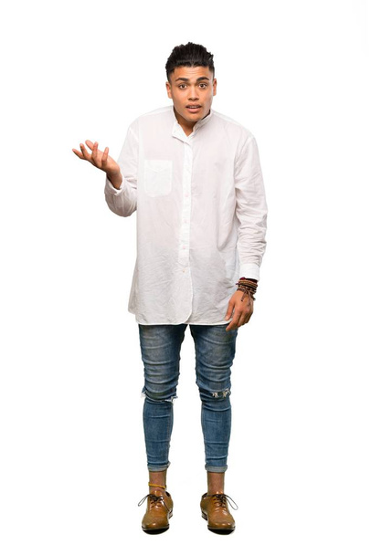 A full-length shot of a Young man making doubts gesture over isolated white background - Fotoğraf, Görsel