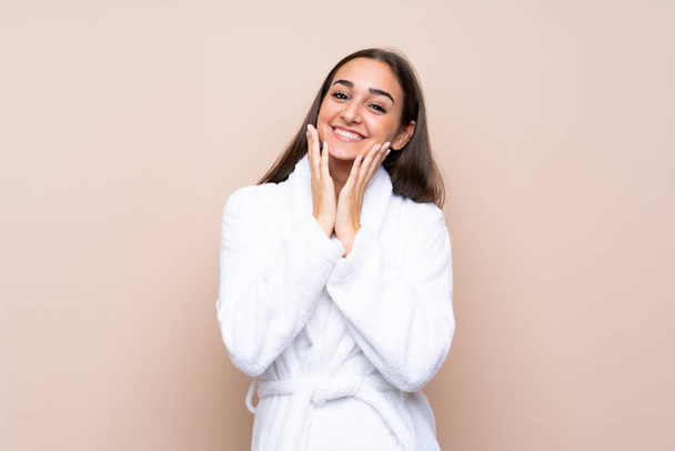 Young girl in a bathrobe over isolated background with surprise facial expression - Photo, Image