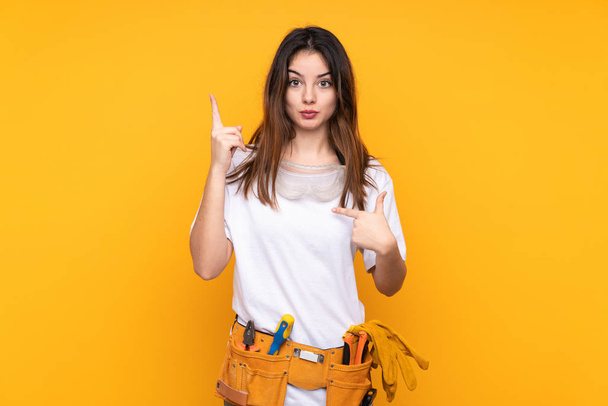 Mujer electricista joven sobre aislado sobre fondo amarillo con expresión facial sorpresa - Foto, Imagen