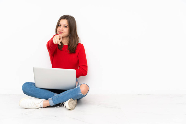 Tenaager Mädchen arbeitet mit PC isoliert auf weißem Hintergrund zeigt mit dem Finger auf Sie mit einem selbstbewussten Ausdruck - Foto, Bild