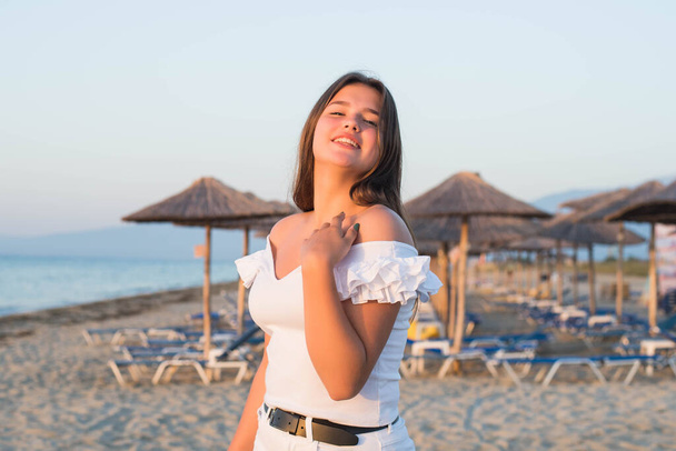 Retrato de adolescente alegre más tamaño adolescente con ropa blanca disfrutando de la playa. sonriente, feliz, emoción positiva, estilo de verano
. - Foto, imagen
