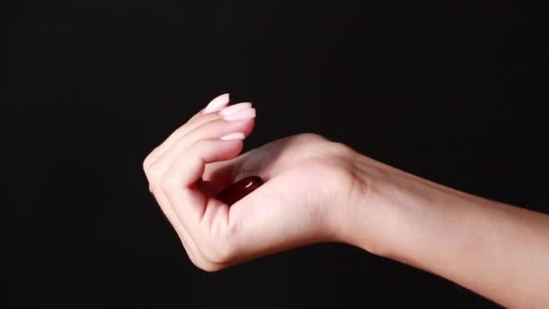 close-up shot van een hand houden kleur pillen op de achtergrond  - Video
