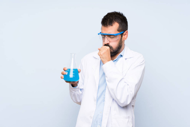 Mladý vědec držení laboratorní baňka přes izolované pozadí trpí kašlem a pocit špatné - Fotografie, Obrázek