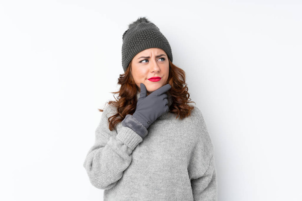 Mujer rusa joven con sombrero de invierno sobre fondo blanco aislado pensando en una idea
 - Foto, imagen
