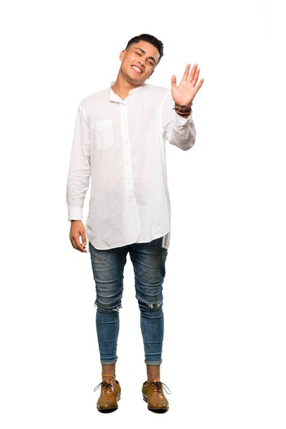 A full-length shot of a Young man saluting with hand with happy expression over isolated white background - Foto, Imagen