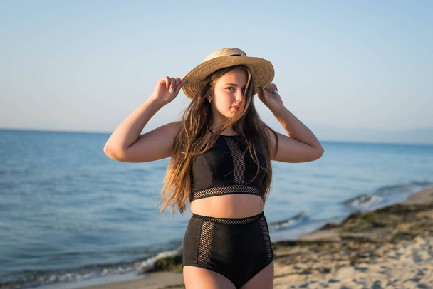 Allegro plus size adolescente indossa cappello godendo la spiaggia. sorridente, felice, emozione positiva, stile estivo. - Foto, immagini