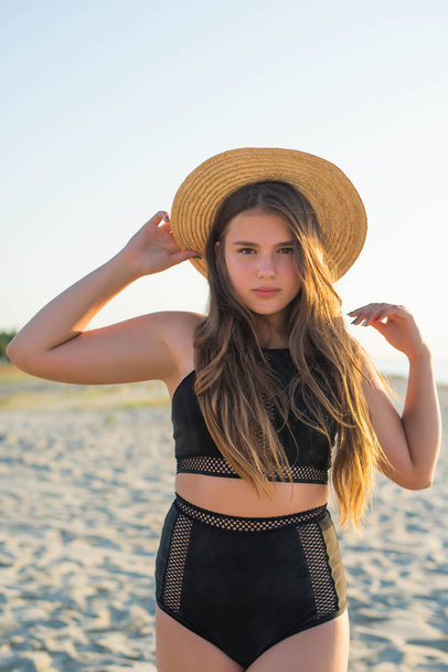 Веселий плюс розмір дівчина-підліток в капелюсі насолоджується пляжем. усміхнені, щасливі, позитивні емоції, літній стиль
. - Фото, зображення
