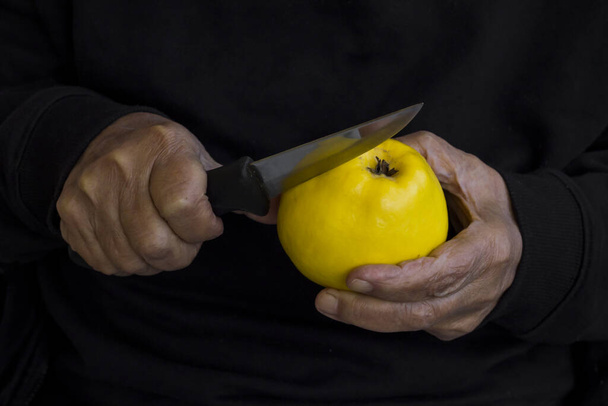 close-up shot of man cutting yellow apple - 写真・画像