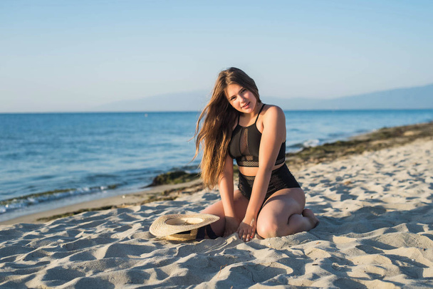 Vrolijk tienermeisje dat geniet van het strand. glimlachen, gelukkig, positieve emotie, zomerse stijl. - Foto, afbeelding