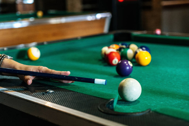 Sports game of billiards on a green cloth. Billiard balls with numbers on a pool table. Billiards team sport. - 写真・画像