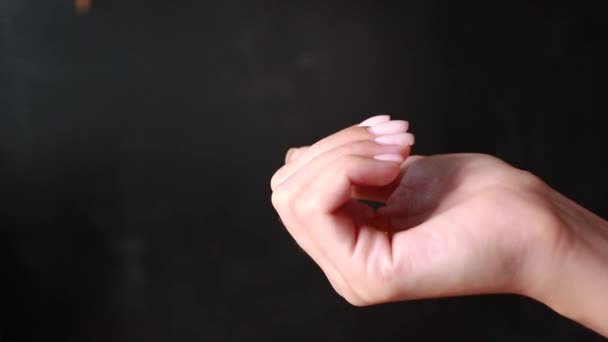 gros plan d'une main tenant des pilules de couleur sur fond
  - Séquence, vidéo