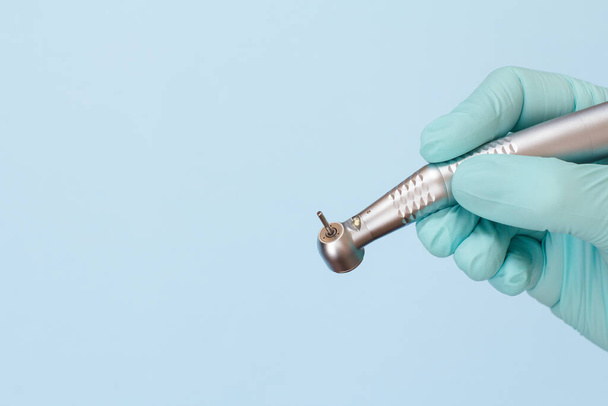 Dentist 's hand in glove with dental handpiece
. - Фото, изображение