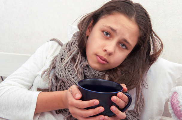 The girl is ill, drinking tea - Foto, afbeelding