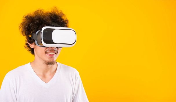 Азиатский красавчик с вьющимися волосами он использует голову виртуальной реальности
 - Фото, изображение
