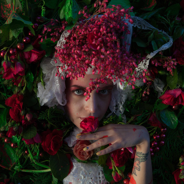 Female portrait in fairy tale stylization surrounded with natural flowers. - Фото, зображення