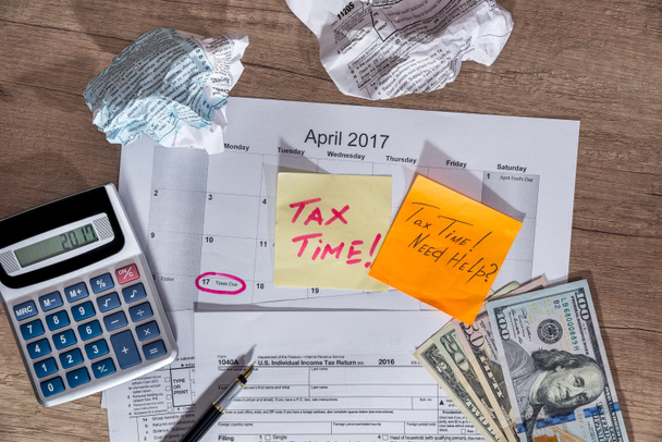 texto "tiempo de impuestos" en formularios de impuestos 1040 con pluma, calculadora y dinero
. - Foto, imagen