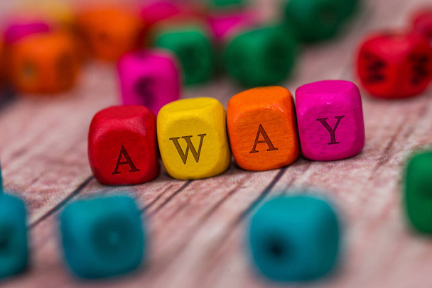 away - mot créé avec des cubes en bois colorés sur le bureau
. - Photo, image