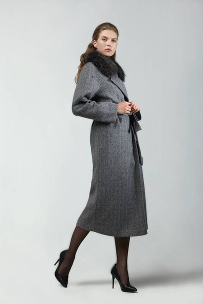 beautiful fashion woman posing in elegant coat at studio - Fotó, kép