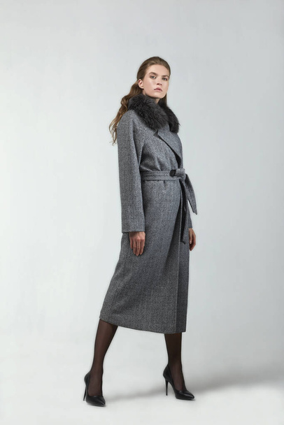 beautiful fashion woman posing in elegant coat at studio - Fotoğraf, Görsel