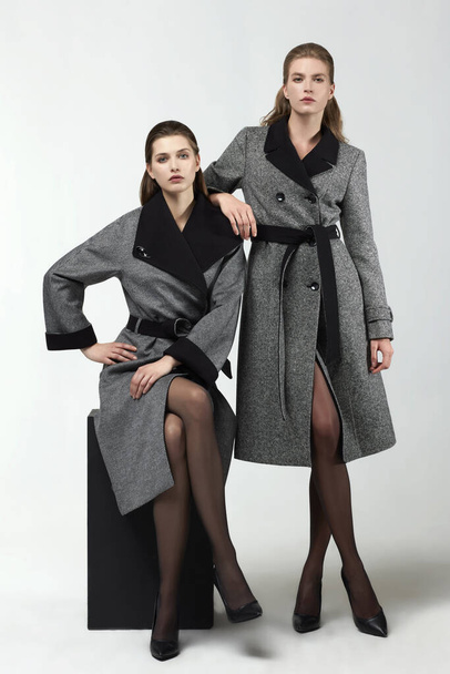 beautiful fashion women posing in elegant coats at studio - Photo, image