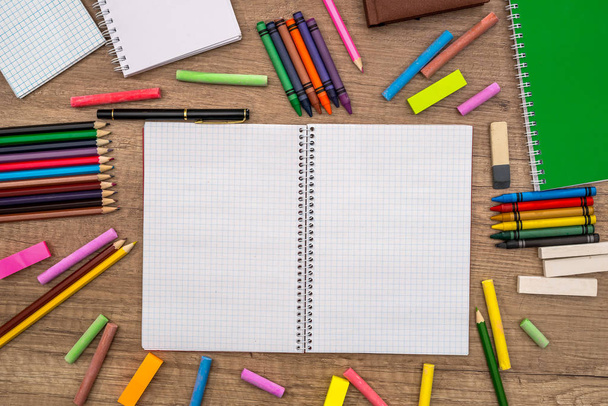 bloc de notas vacío con tizas de color y lápices en el escritorio
. - Foto, imagen