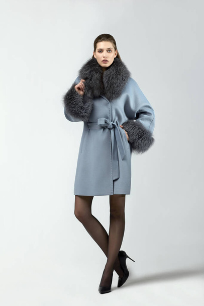 beautiful fashion woman posing in elegant coat at studio - Foto, imagen