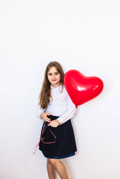 European-looking girl on a white background holding a heart-shaped balloon, balloon, heart, love, Valentine's day, birthday, holiday - Photo, image
