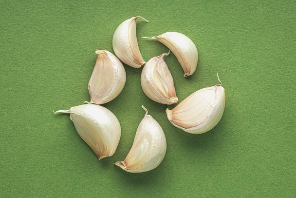 Garlic cloves isolated on green - Foto, Imagen