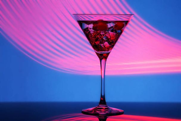 Glass of martini with ice and olives in neon light - Foto, imagen