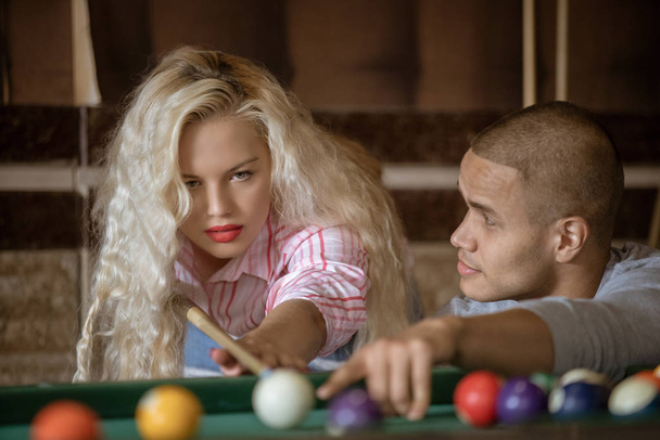Young couple playing snooker together in bar - Zdjęcie, obraz